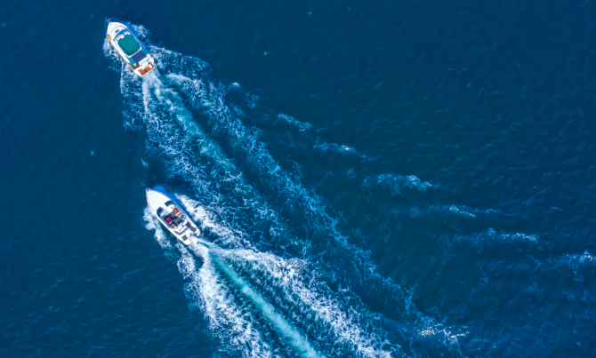 Two small high-speed boats creating wakes at sea. Two small high-speed boats creating wakes at sea.