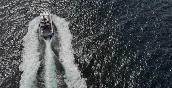 Vessel creating large foamy wake while moving fast. Vessel creating large foamy wake while moving fast.