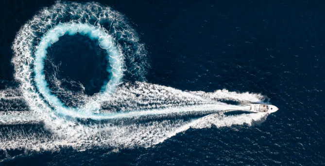 Boat turning sharply, leaving curved wake trail. Boat turning sharply, leaving curved wake trail.