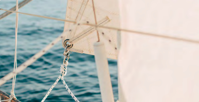 Sailboat at sea with crew adjusting sails. Sailboat at sea with crew adjusting sails.