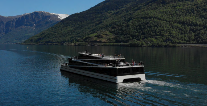 Passenger ferry navigating near coastline with trees. Passenger ferry navigating near coastline with trees.