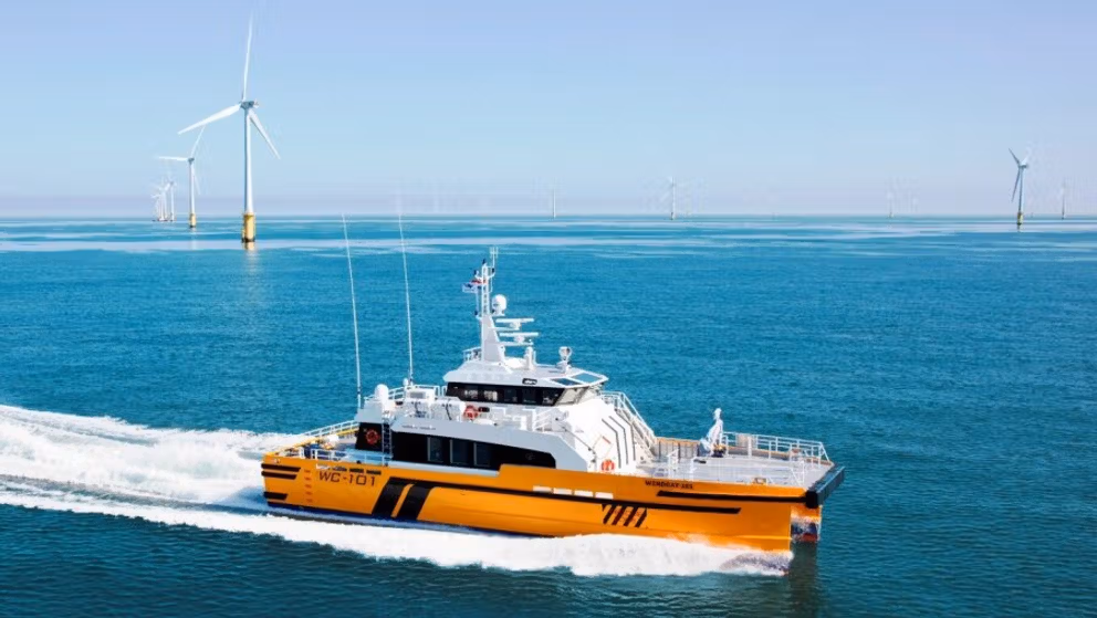 Orange offshore workboat operating near wind turbines. Orange offshore workboat operating near wind turbines.